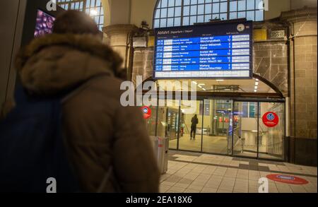 Hagen, Allemagne. 07e février 2021. Un homme se tient devant le tableau d'affichage pour montrer les retards et les annulations de train à la gare principale. Pendant la nuit, il y a eu de fortes chutes de neige dans de grandes parties de la Rhénanie-du-Nord-Westphalie. Credit: Jonas Güttler/dpa/Alay Live News Banque D'Images