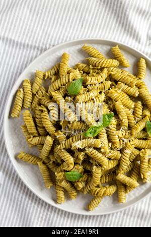 Pesto maison Twist Pasta sur une assiette sur tissu, vue de dessus. En hauteur, par le dessus, à plat. Gros plan. Banque D'Images