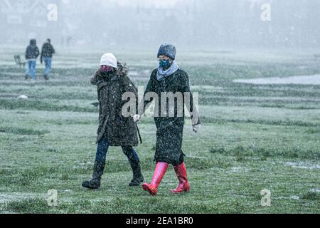 WIMBLEDON LONDRES, ROYAUME-UNI 7 FÉVRIER 2021. Les gens portent des marques faciales lors d'une douche à neige sur Wimbledon Common alors que Storm Darcy arrive au Royaume-Uni ce matin avec des températures glaciales. Le met Office a émis des avertissements de neige et de glace jaunes et des chutes de neige perturbatrices dans le sud-est de l'Angleterre avec des gales froides de 50 km/h en provenance de Russie et d'Ukraine surnommés « mini Beast de l'est Credit: amer ghazzal/Alamy Live News Banque D'Images