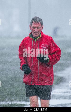 WIMBLEDON LONDRES, ROYAUME-UNI 7 FÉVRIER 2021. Un jogging court lors d'une douche à neige sur Wimbledon Common alors que Storm Darcy arrive au Royaume-Uni ce matin avec des températures glaciales. Le met Office a émis des avertissements de neige et de glace jaunes et des chutes de neige perturbatrices dans le sud-est de l'Angleterre avec des gales froides de 50 km/h en provenance de Russie et d'Ukraine surnommés « mini Beast de l'est Credit: amer ghazzal/Alamy Live News Banque D'Images