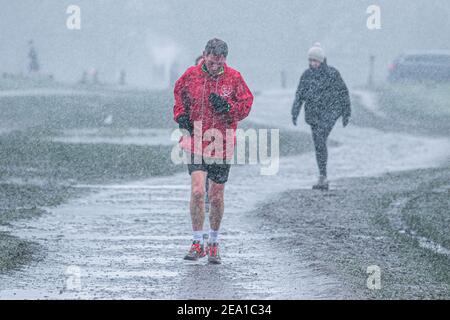 WIMBLEDON LONDRES, ROYAUME-UNI 7 FÉVRIER 2021. Un jogging court lors d'une douche à neige sur Wimbledon Common alors que Storm Darcy arrive au Royaume-Uni ce matin avec des températures glaciales. Le met Office a émis des avertissements de neige et de glace jaunes et des chutes de neige perturbatrices dans le sud-est de l'Angleterre avec des gales froides de 50 km/h en provenance de Russie et d'Ukraine surnommés « mini Beast de l'est Credit: amer ghazzal/Alamy Live News Banque D'Images