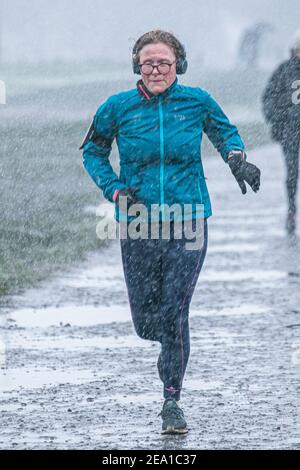 WIMBLEDON LONDRES, ROYAUME-UNI 7 FÉVRIER 2021. Un jogging court lors d'une douche à neige sur Wimbledon Common alors que Storm Darcy arrive au Royaume-Uni ce matin avec des températures glaciales. Le met Office a émis des avertissements de neige et de glace jaunes et des chutes de neige perturbatrices dans le sud-est de l'Angleterre avec des gales froides de 50 km/h en provenance de Russie et d'Ukraine surnommés « mini Beast de l'est Credit: amer ghazzal/Alamy Live News Banque D'Images