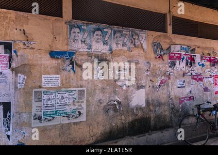 Le vieux papier d'affiche déchiré la texture sur une rue jaune mur Banque D'Images