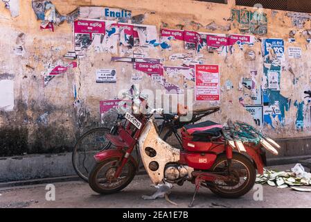 Cycle moteur devant un vieux papier d'affiche déchiré gratter la texture sur un mur de rue jaune Banque D'Images