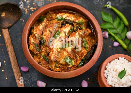 Vue de dessus Sardine poisson curry femme épicée à la main prendre Kerala poisson curry riz Inde, nourriture indienne piment rouge, feuille de curry. Cuisine asiatique. Délicieux épicé Banque D'Images