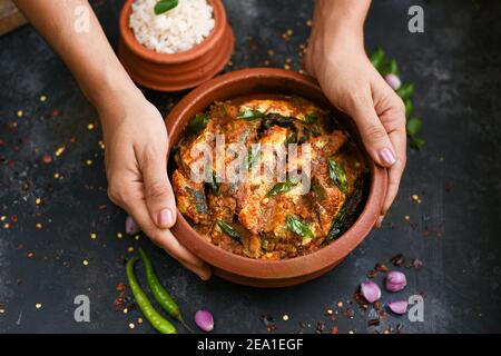 Vue de dessus Sardine poisson curry femme épicée à la main prendre Kerala poisson curry riz Inde, nourriture indienne piment rouge, feuille de curry. Cuisine asiatique. Délicieux épicé Banque D'Images