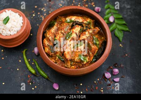 Vue de dessus Sardine poisson curry femme épicée à la main prendre Kerala poisson curry riz Inde, nourriture indienne piment rouge, feuille de curry. Cuisine asiatique. Délicieux épicé Banque D'Images