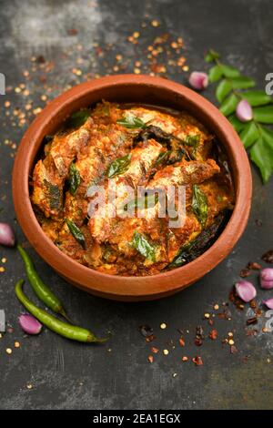 Vue de dessus Sardine poisson curry femme épicée à la main prendre Kerala poisson curry riz Inde, nourriture indienne piment rouge, feuille de curry. Cuisine asiatique. Délicieux épicé Banque D'Images