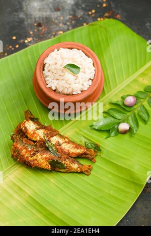 Vue de dessus Sardine poisson curry femme épicée à la main prendre Kerala poisson curry riz Inde, nourriture indienne piment rouge, feuille de curry. Cuisine asiatique. Délicieux épicé Banque D'Images