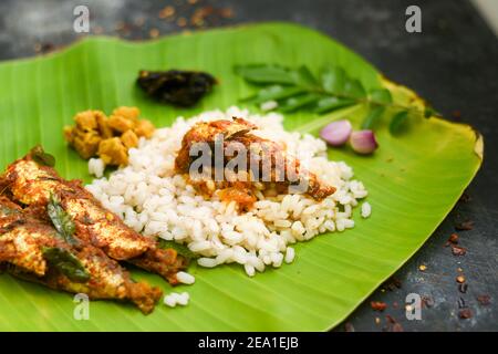 Vue de dessus Sardine poisson curry femme épicée à la main prendre Kerala poisson curry riz Inde, nourriture indienne piment rouge, feuille de curry. Cuisine asiatique. Délicieux épicé Banque D'Images