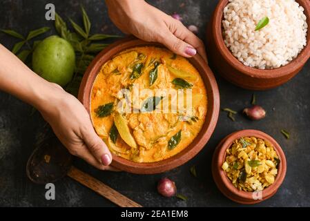 Vue de dessus Epicé chaud Bengali Rohu ou le curry de poisson Roi. Cuisine indienne. Curry de poisson avec piment rouge, feuille de curry. Cuisine asiatique. Femme prendre main Kerala épicé, Banque D'Images