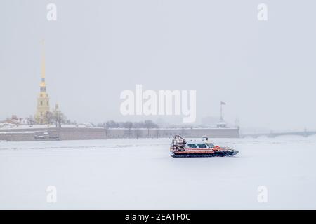 Saint-Pétersbourg, Russie - 06 février 2021. Un aéroglisseur de service de recherche et de sauvetage dans la zone d'eau couverte de glace de la Neva, en toile de fond o Banque D'Images