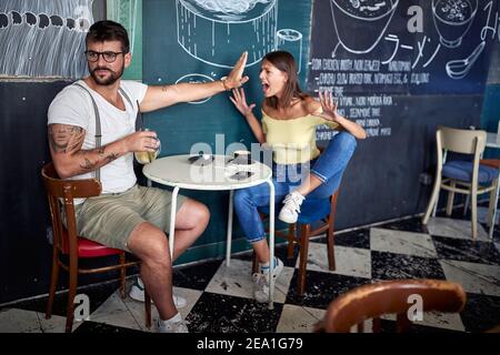 Couple moderne ayant un combat dans un café Banque D'Images