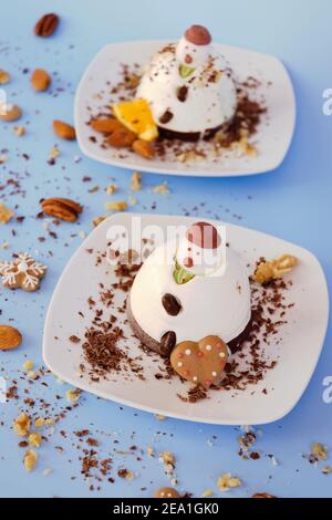 Fond de glace en forme de deux bonhommes de neige comestibles sur des assiettes blanches. Vue de dessus. Une idée créative pour les desserts de Noël et du nouvel an Banque D'Images