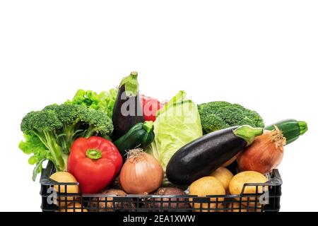 Panier de légumes coloré isolé et rempli de brocoli, laitue, aubergines, oignons, courgettes, poivrons et pommes de terre. Banque D'Images