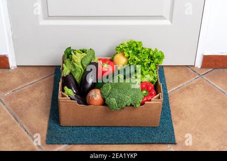 Livraison de légumes frais biologiques pendant une pandémie, porte-à-porte à chaque client. Concept de commande en ligne. Banque D'Images