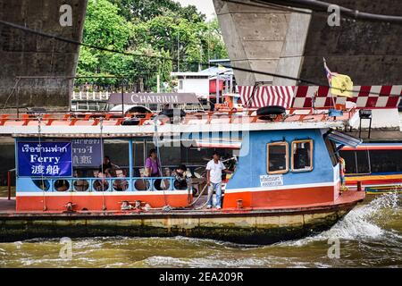 Bangkok, Thaïlande 08.20.2019 UN ferry avec des passagers sous le pont Taksin, près de la jetée de Sathorn sur la rivière Chao Phraya Banque D'Images