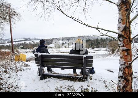 Les marcheurs se reposent et offrent une vue sur la neige près du réservoir Langsett dans le South Yorkshire, avec de fortes chutes de neige qui perturbent le sud-est de l'Angleterre et l'est des Anglia, tandis que les vents amèrement froids s'embuent sur une grande partie de la nation. Date de la photo: Dimanche 7 février 2021. Banque D'Images