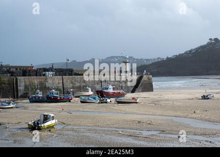 Vue panoramique sur de nombreux bateaux de pêche et d'autres posés sur le sable dans le port de St Ives. Vide et calme en raison du confinement global en cas de pandémie Covid-19 Banque D'Images