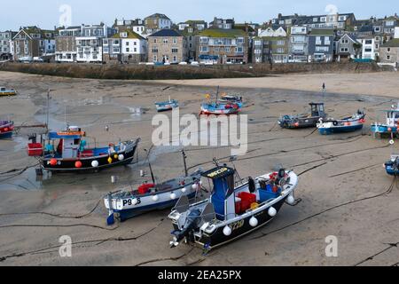 Vue panoramique sur de nombreux bateaux de pêche et d'autres posés sur le sable dans le port de St Ives. Vide et calme en raison du confinement global en cas de pandémie Covid-19 Banque D'Images