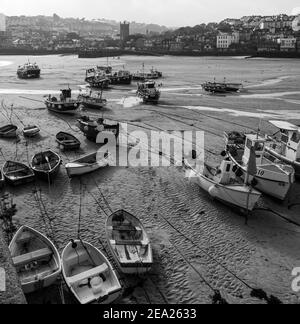 Vue panoramique sur de nombreux bateaux de pêche et d'autres posés sur le sable dans le port de St Ives. Vide et calme en raison du confinement global en cas de pandémie Covid-19 Banque D'Images