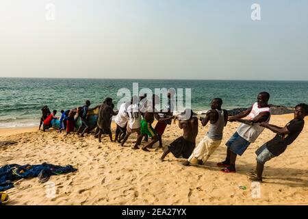 Les pêcheurs locaux tirent leurs filets sur une plage de Robertsport, au Libéria Banque D'Images