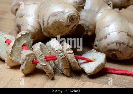 Tuber de gingembre (Zingiber officinale) et tranches séchées Banque D'Images