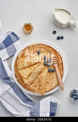 Crêpes, crêpes fines ou blini avec baies dans une assiette blanche. Vue de dessus. Semaine des crêpes. Shrovetide. Espace pour le texte. Banque D'Images