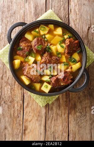 Savoureux Aloo Gocht recette mutton Curry avec pommes de terre dans la casserole sur la table. Vue verticale du dessus Banque D'Images