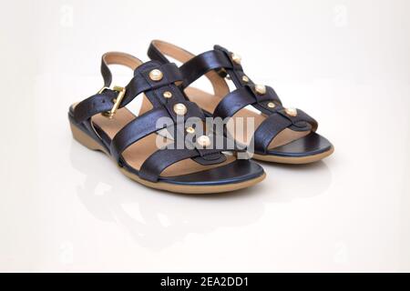 Sandales en cuir bleu pour femmes isolées sur fond clair. Réflexion miroir Banque D'Images