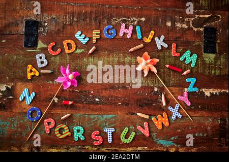 Auburn table en bois avec des lettres colorées qui montrent l'alphabet allongé dans un cercle. Banque D'Images