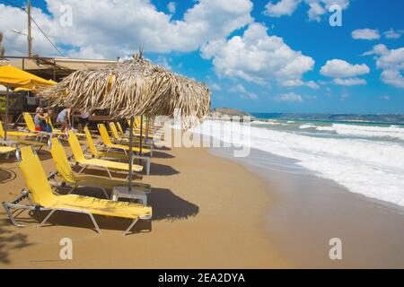 Kalyves,CRÈTE-GRÈCE:JUILLET 5 2017.Crete plage Kalyves. Parasols et chaises longues jaunes sur fond d'une belle mer bleue par une belle journée ensoleillée. Public Banque D'Images