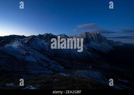 La cabane de Rifugio Genève et les rochers enneigés et les falaises des sommets Geisler des montagnes Puez-Odle brillent à l'aube, Dolomites, Tyrol du Sud, Italie Banque D'Images