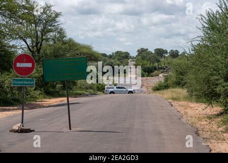 Une route fermée dans le parc national Kruger à cause de l'eau s'écoulant sur le pont Banque D'Images