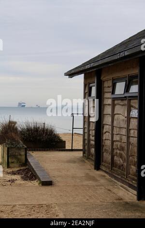 Toilettes publiques à côté du Knoll Beach Cafe sur Studland, Dorset. Angleterre. Les bateaux de croisière sont ancrés en raison de leur maintien dans la distance. Banque D'Images