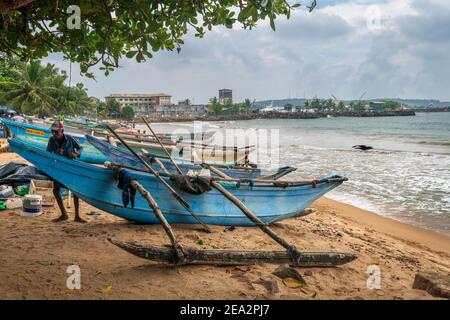 Un homme vérifie son bateau de pêche en catamaran sur la plage de Galle au Sri Lanka, après son retour d'un voyage de pêche. Banque D'Images