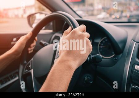 le conducteur garde fermement les mains sur le volant de sa voiture. Le concept de l'apprentissage de la conduite et de la sécurité sur la route Banque D'Images