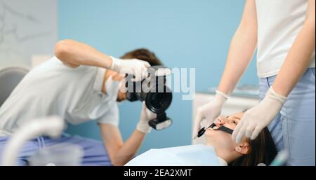 Dentiste photographiant le résultat de son travail Banque D'Images