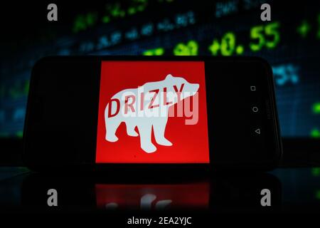 Pologne. 07e février 2021. Sur cette photo, un logo Drizly apparaît sur l'écran d'un smartphone avec un graphique boursier en arrière-plan. Crédit : SOPA Images Limited/Alamy Live News Banque D'Images