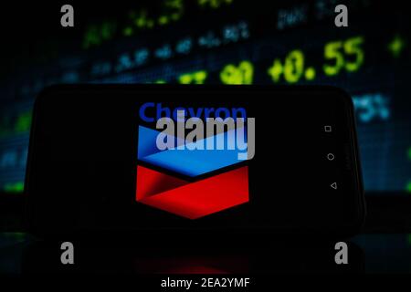 Pologne. 07e février 2021. Sur cette photo, un logo Chevron apparaît sur l'écran d'un smartphone avec un graphique boursier en arrière-plan. Crédit : SOPA Images Limited/Alamy Live News Banque D'Images