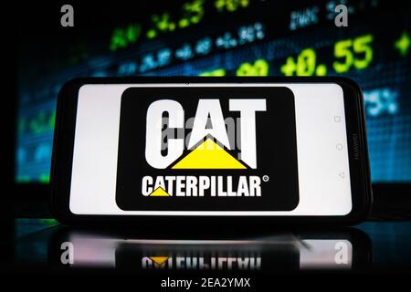 Pologne. 07e février 2021. Sur cette photo, un logo CAT apparaît sur l'écran d'un smartphone avec un graphique boursier en arrière-plan. Crédit : SOPA Images Limited/Alamy Live News Banque D'Images
