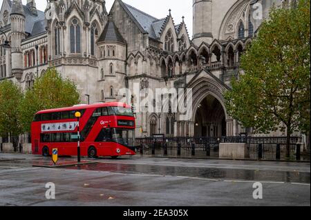 Bus rouge de Londres passant par les cours royales de justice, Londres Banque D'Images