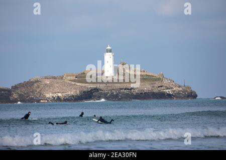 Surfeurs vus de St Gothian Sands à Cornwall, Royaume-Uni Banque D'Images