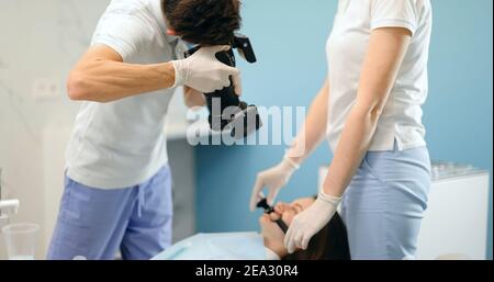 Dentiste photographiant le résultat de son travail Banque D'Images