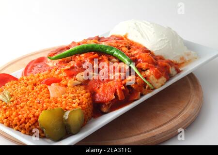 Cuisine turque. Donner de la viande de kebab avec des pommes de terre frites et de la salade sur une assiette isolée sur fond blanc Banque D'Images