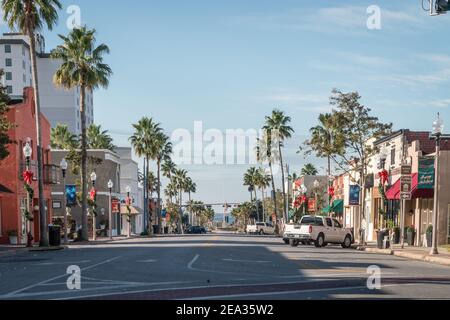 Main Street dans le centre-ville de Panama City, Floride, Etats-Unis bordé de bâtiments peints de couleurs vives et de palmiers pendant la période des fêtes de Noël. Banque D'Images