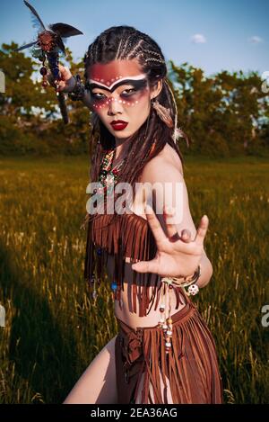 Portrait extérieur de la jolie jeune shamaness (sorcière) dans la prairie au coucher du soleil. Charmant shaman (sorcière) se préparant à la bataille Banque D'Images