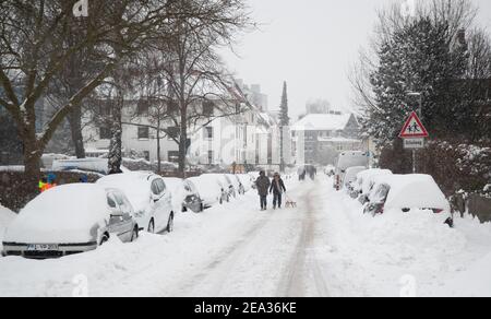 Bielefeld, Allemagne. 07e février 2021. Les marcheurs avec un traîneau marchent sur une route enneigée. Credit: Friso Gentsch/dpa/Alay Live News Banque D'Images