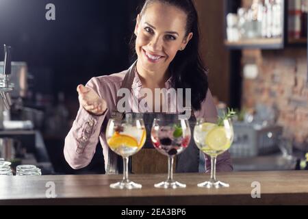 Le bar Bartender propose une sélection de boissons toniques au gin. Banque D'Images