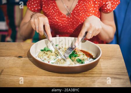 Manti - un plat de délicatesse de l'Asie centrale, est un parent de boulettes et raviolis. Servi avec de la sauce sur une assiette dans un café Banque D'Images